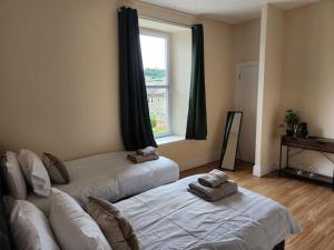 een woonkamer met 2 bedden en een raam bij West End Dream in Dundee