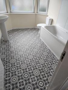 a bathroom with a tub and a toilet and a sink at West End Dream in Dundee