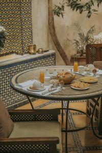 einen Tisch mit Teller mit Lebensmitteln darüber in der Unterkunft Riad Samsara in Marrakesch