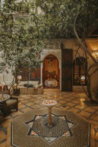 Riad Samsara في مراكش: غرفة مع طاولة في منتصف الغرفة