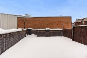 a parking lot covered in snow next to a brick building at Spacious 2 bedroom apartment - 02 in Montreal