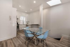 a dining room with a glass table and blue chairs at Spacious 2 bedroom apartment - 02 in Montreal