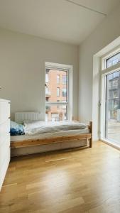 um quarto com uma cama e uma grande janela em ApartmentInCopenhagen Apartment 1573 em Copenhaga