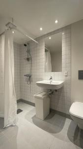 uma casa de banho com um lavatório, um WC e um espelho. em ApartmentInCopenhagen Apartment 1573 em Copenhague