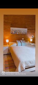 1 dormitorio con 1 cama blanca grande y 2 lámparas en Casitas De Montaña en Traslasierra 2 en Los Hornillos