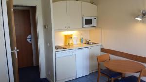 una pequeña cocina con mesa y microondas en Private Studio - Paris - La Défense en Courbevoie