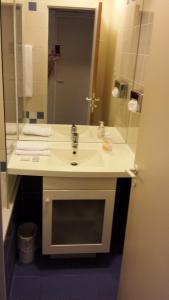 a bathroom with a white sink and a mirror at Private Studio - Paris - La Défense in Courbevoie