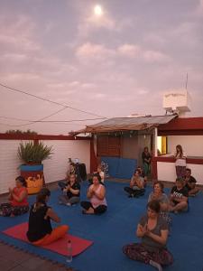 門多薩的住宿－"B" SPACIO Hostel y Arte -Habitación Compartida-，一群坐在地板上做瑜伽的人