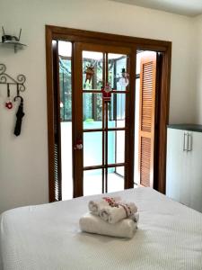 a bed with two towels on top of it in front of a door at Refúgio na Serra, um espaço para ser desfrutado! in Gramado
