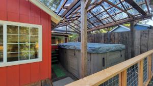 una pérgola al lado de una casa roja en River Views 2 Homes Sleeps 14 Swim Spa, en Rogue River