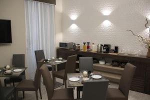 Residenza Suarez في نابولي: غرفة طعام مع طاولتين وكراسي وأضواء