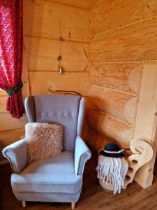 a chair in a room with a wooden wall at Góralski Domek Łopatówka z kominkiem i Banią - Jacuzzi! in Murzasichle