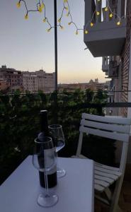 un tavolo con due bicchieri e una bottiglia di vino di Your Happy Home a Roma