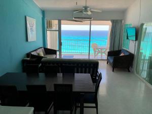 a living room with a table and a view of the ocean at Beautiful Beach Front Pent House in Cancun!!! in Cancún