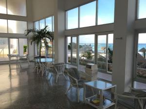 a large room with tables and chairs and windows at Beautiful Beach Front Pent House in Cancun!!! in Cancún