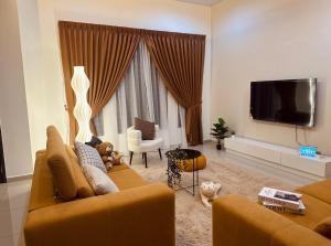 a living room with a couch and a tv at Kluang 4 bedrooms 4 bathrooms in Kluang