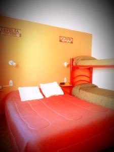 Ce lit rouge se trouve dans un dortoir doté de 2 lits superposés. dans l'établissement SPACIO HABITACION APART Baño Privado Estar con microondas y frigobar, à Mendoza