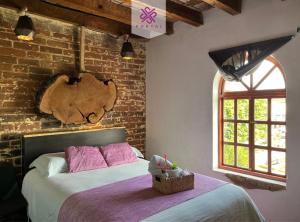 een slaapkamer met een bed en een bakstenen muur bij Hotel Portal & Suites in Ciudad Hidalgo