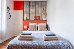 een slaapkamer met een groot bed met kussens erop bij Charmant & Cosy 2 pièces La Defense-Champs Elysees in Puteaux
