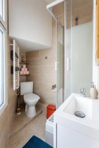 een witte badkamer met een toilet en een wastafel bij Charmant & Cosy 2 pièces La Defense-Champs Elysees in Puteaux