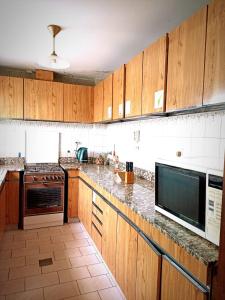 cocina con armarios de madera y encimera en "A" SPAcio HOSTEL -HABITACION PRIVADA- en Mendoza