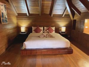 ein Schlafzimmer mit einem Bett mit zwei Schwänen darauf in der Unterkunft Lantana House in Ban Pa Muang