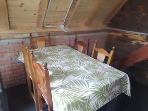 a table with a white and green table cloth on it at Cabañas sarai in Perito Moreno