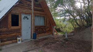 eine Hütte mit einer weißen Tür und einem Fenster in der Unterkunft Cabañas sarai in Perito Moreno