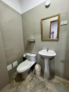 Łazienka z białą toaletą i umywalką w obiekcie Fitzcarrald Hotel w mieście Iquitos