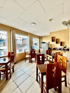 una sala da pranzo con tavoli e sedie e una cucina di Fitzcarrald Hotel a Iquitos