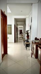 um corredor com piso em azulejo branco e um corredor com mesas em Fitzcarrald Hotel em Iquitos