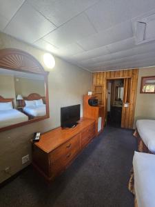 um quarto de hotel com um quarto com duas camas e uma televisão em Redrock Country Inn em Kanab