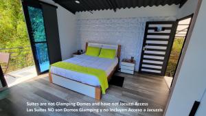um quarto com uma cama com lençóis verdes e uma varanda em Solaris Glamping Exclusive em Tena