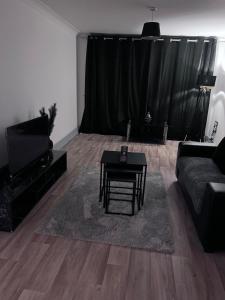 a living room with a couch and a table at Broad street - Balcony 1 bedroom apartment in Birmingham