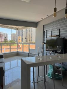 a living room with a table and two wine glasses at Apartamento em águas claras in Águas Claras