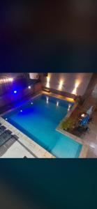 a large blue swimming pool at night with lights at La Familia Hotel in Puerto Iguazú