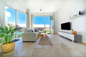 a living room with a white couch and a tv at Villa Cacemar Salobre Golf in Las Palmas de Gran Canaria