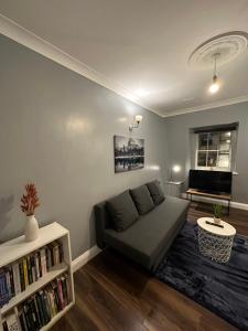 a living room with a couch and a book shelf at 1 bedroom in kingscross, St Pancras, London in London