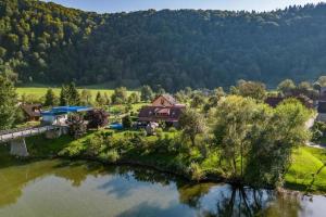 - une vue aérienne sur une maison à côté d'une rivière dans l'établissement Family friendly house with a swimming pool Blazevci, Gorski kotar - 21038, à Vrbovsko