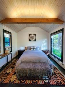 ein Schlafzimmer mit einem großen Bett und zwei Fenstern in der Unterkunft Belleayre Lodge in Pine Hill