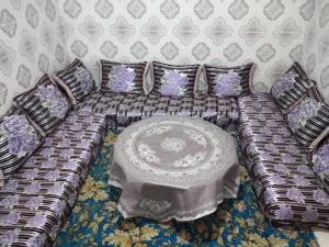 ein Sofa mit einem Tisch in einem Zimmer in der Unterkunft Aziz House 2 in Tan-Tan