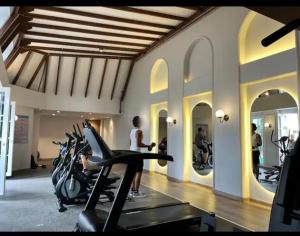 una habitación con un gimnasio con motocicletas y una persona en una cinta de correr en Exclusivo apto en sabaneta, en Sabaneta