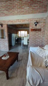 uma sala de estar com um sofá e uma parede de tijolos em Casa de Playa em Playas Doradas
