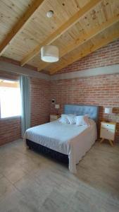 um quarto com uma cama grande numa parede de tijolos em Casa de Playa em Playas Doradas