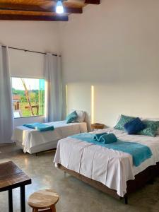 a bedroom with two beds and a window at Chalé Escarpas in Capitólio