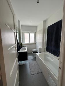 een badkamer met een bad, een toilet en een wastafel bij Rooms to rent in a friendly apartment in Lissabon