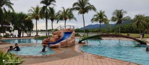 een zwembad met een glijbaan in een resort bij Villa Dalam laut 530 in Pantai Cenang