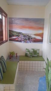 a room with two benches with a painting on the wall at Aconchego de Maria in Piranhas
