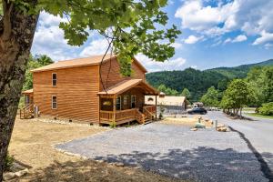 SmokiesBoutiqueCabins would love to host you at Dolly's Cute Cabin! 4 Suites with Private Bathrooms - Hot Tub, Fire Pit, Game Room, Resort Pool open Memorial Day through Labor Day! في غاتلينبرغ: منزل خشبي كبير أمامه شجرة