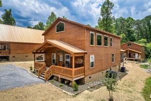 a large wooden house with a porch at SmokiesBoutiqueCabins would love to host you at Dolly's Cute Cabin! 4 Suites with Private Bathrooms - Hot Tub, Fire Pit, Game Room, Resort Pool open Memorial Day through Labor Day! in Gatlinburg